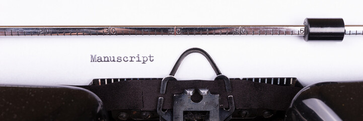 The word Manuscript typed on retro black typewriter. Panoramic image