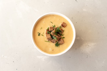 Tomato soup in a black bowl on grey stone background. Top view. Copy space.