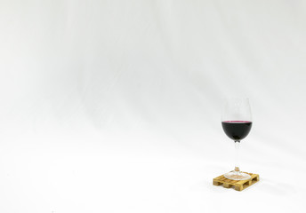 Glass of wine sits on the pallete in white background. Blank space image. Deliveries and...