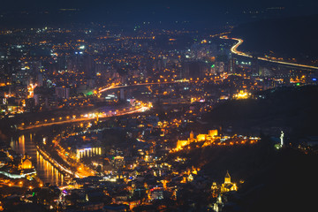 Mtkvari river and surounded areas with smog in the air in Tbilisi at night. Lightrails. Pollution and traffic in Georgia. Sakartvelo.2020