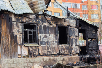 The charred wall of the house, the arson close-up. The destruction of a village house on the outskirts of the city