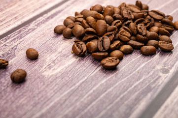 Roasted coffee beans on a wooden background. Close up.