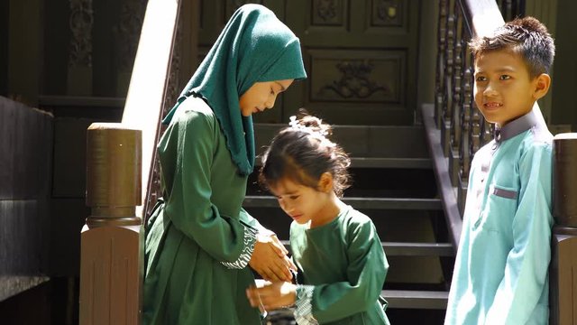 sister and brother greeting in front of their house
