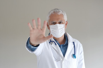 Doctor with protection mask stopping virus spreading, isolated
