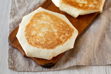 Crispy Homemade Beef Crunchwrap Quesadilla on a rustic wooden board, close-up.