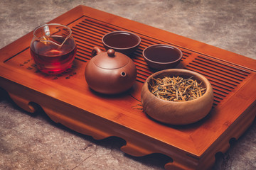 Chinese tea in Yixing clay teapot with teaware stand on tea tray