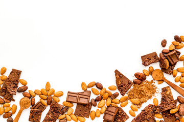 Chocolate frame. Broken slices and nuts on white background top-down copy space