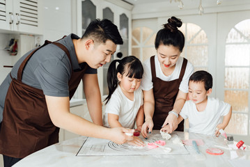 Fototapeta premium The family is baking bread in the kitchen