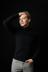 Naklejka premium Portrait of determined goodlooking man wearing black shirt, black background.