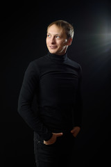 Naklejka premium Portrait of determined goodlooking man wearing black shirt, black background.