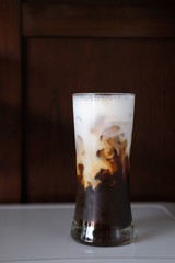 Iced coffee with milk on table