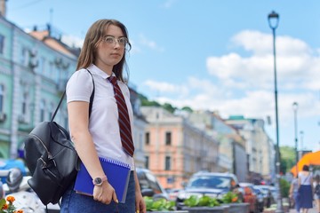 Girl 17, 18 years old high school student in city looking to side, copy space