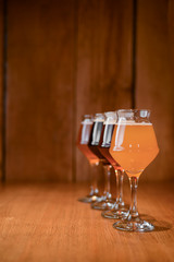 Three glasses with different beer on wooden table in a bar. Food photography concept, with copy space