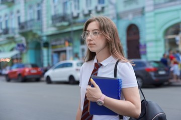 Girl 17, 18 years old high school student in city looking to side, copy space