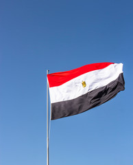 National flag of Egypt flying high against the blue sky