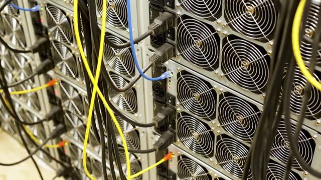 Bitcoin cryptocurrency mining farm. Stock footage. Close up of machines for mining bitcoins, professional equipment and modern technologies concept.