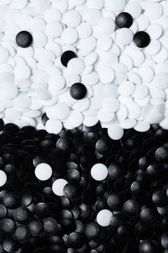 Abstract black and white background of textured circles. Black and white stones of traditional Chinese strategy board game "GO", "Othello".