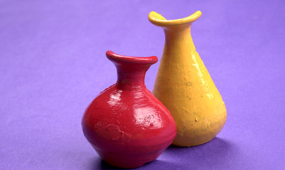 Beautiful empty decorative ceramic pots in warm happy colors on colorful background.