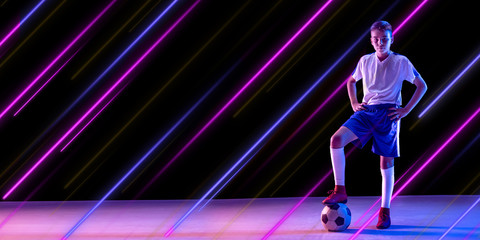 Fototapeta na wymiar Creative sport and neon lines on dark background, flyer, proposal. Male soccer, football player training in action and motion. Concept of hobby, healthy lifestyle, youth, action, movement, modern