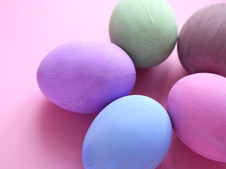 Flat lay composition of Happy Easter holiday concept. Colorful pastel egg on pink background. Close up.