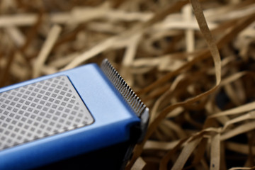 hair clipper on a light straw background