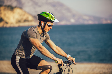 Man ride mountain bike on the beach. Sport and active life concept.