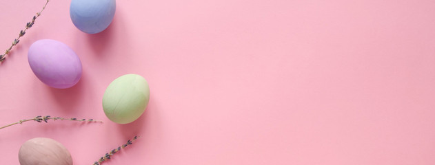 Flat lay composition of Happy Easter holiday concept. Colorful pastel egg with lavender flower on pink background. Copyspace, top view, banner.
