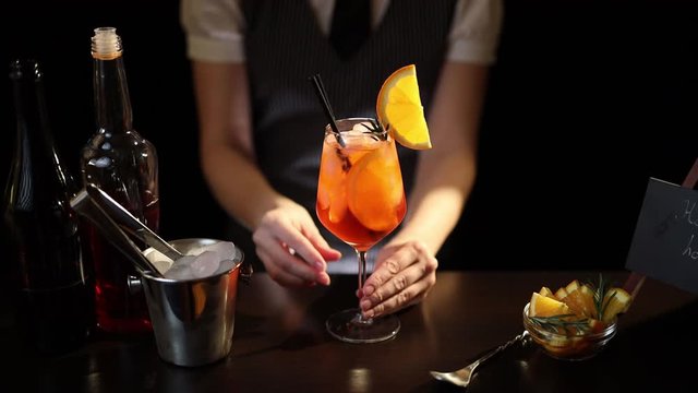 Bartender adding drinking straws into cocktail glass