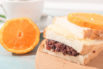 Naklejka na ściany i meble Red bean sandwich with cream cheese, lemon and cup beside the sun