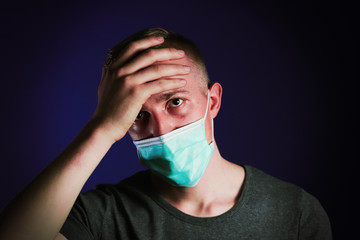 Caucasian sick man in a medical gause mask with palm on his head. Virus prevention concept