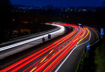 Fototapeta na wymiar Autobahn Deutschland Abenddämmerung Lichtspruren Anschlussstelle Ausfahrt Auffahrt Brücke Kurve Iserlohn Sauerland Blaue Stunde Dämmerung Feierabend Speed Rush Hour