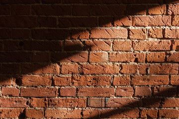Light and shadow from the window.  Lines of light on a brick wall.