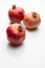 Pomegranate isolated on white background three whole red. Selective focus