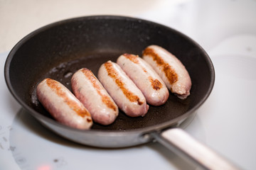 sausages are fried in pan. semi-finished products.