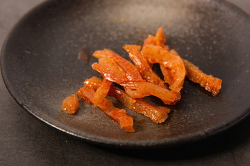 Homemade spicy dry tofu is a good snack on a black plate