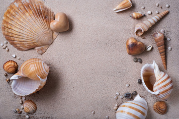 Fototapeta na wymiar Shells and stone hearts on the sand. 