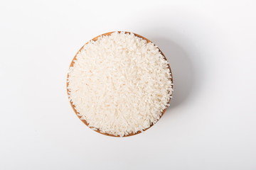 Raw rice in a wooden bowl against a white background