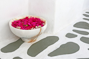 traditional cycladic pavement at Koufonisia islands Greece with flower pot full of pink bougainvillea flowers