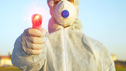 POV Doctor wearing a facemask is measuring temperature with infrared thermometer