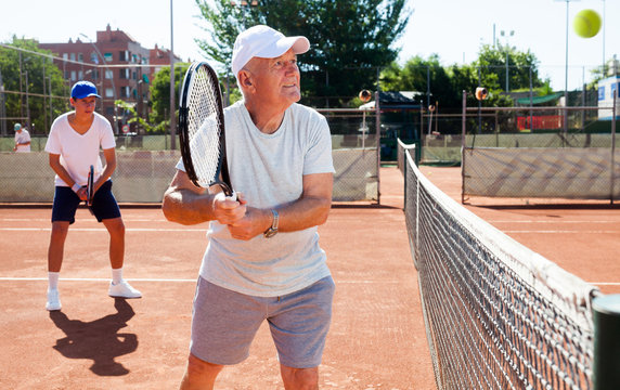 grandfather and grandson playing tennis court