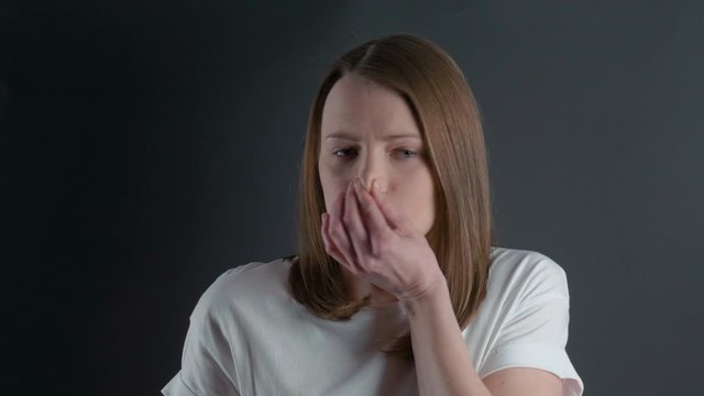 Young girl smells and closes her nose