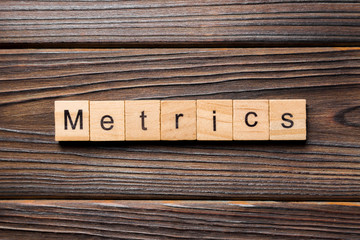 METRICS word written on wood block. METRICS text on wooden table for your desing, concept