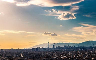 Tehran skyline in a beautiful cloudy day with golden hour light Tehran-Iran cityscape with Milad tower in photo and white clouds and lovely blue sky