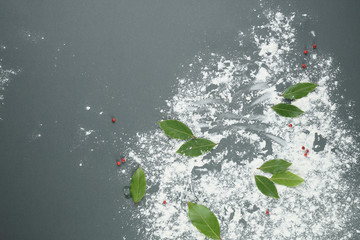 Flour on a grey background with Bay leaves for food design