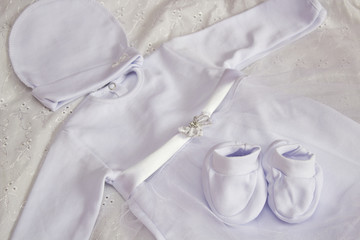 Fototapeta na wymiar white baby clothes for baptism,white dress with booties and hat for the girl for baptism