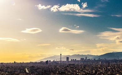 Tehran skyline in a beautiful cloudy day with golden hour light Tehran-Iran cityscape with Milad tower in photo and white clouds and lovely blue sky