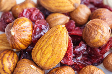 Peeled almonds, hazelnuts and dried cherries closeup. Macro photo of nuts. The concept of healthy...