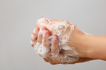 Hand washing with soap on a gray background. Hygiene prevention coronavirus virus disinfection. Close-up