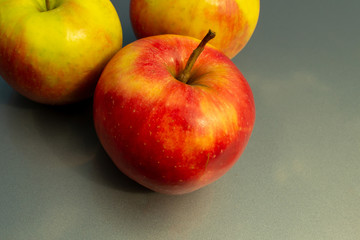 Three apples on a gray background