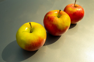 Three apples on a gray background
